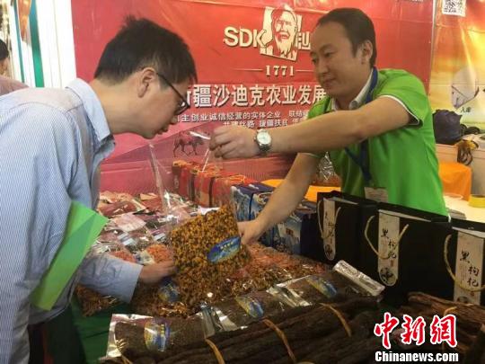 客商向采购商推介果品 卢育辛 摄